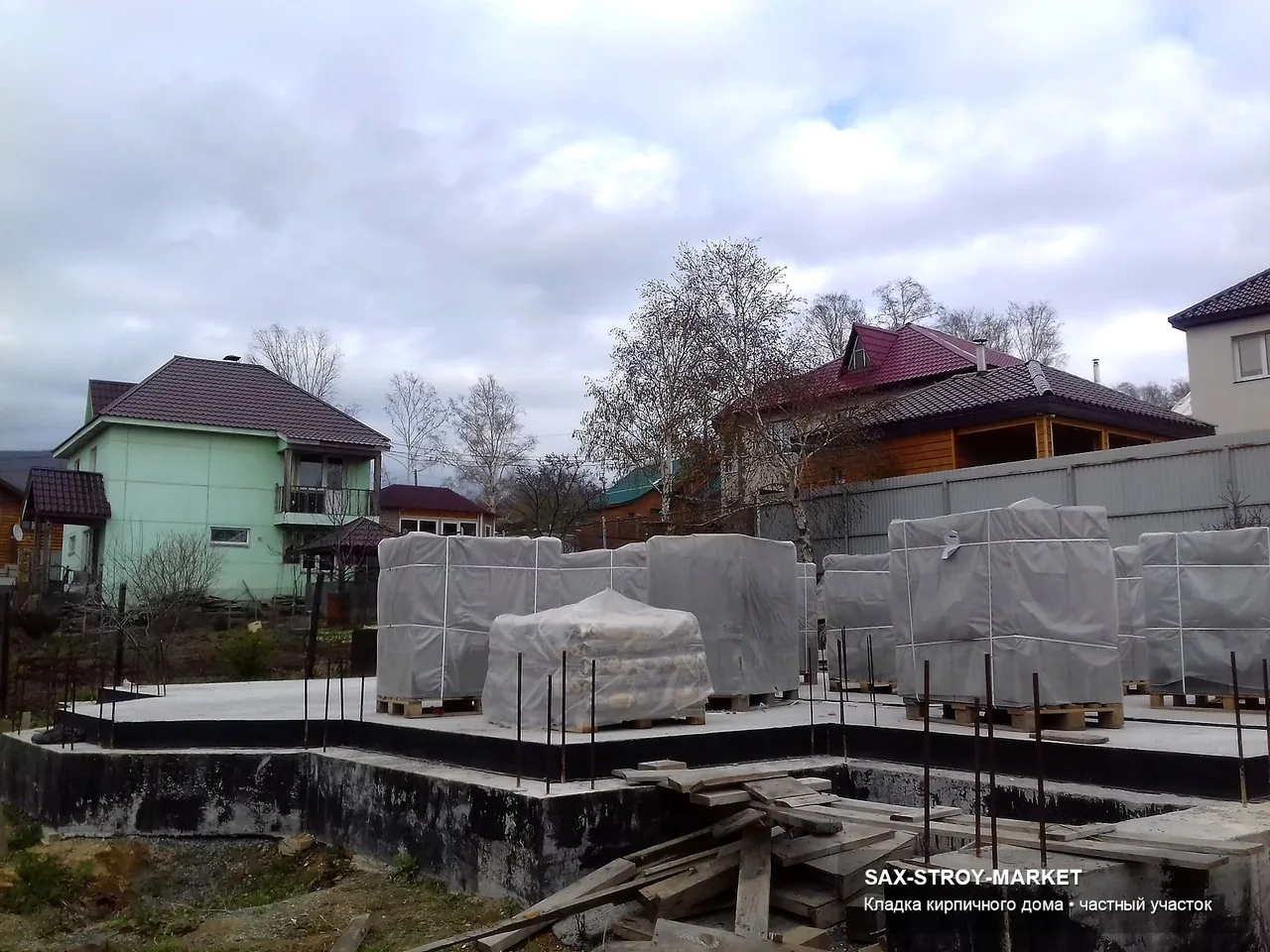 Готовый дом и участок: читается крыльцо, подъезд, двор, терраса и цокольная зона на стороне будущего двора. Такой ракурс нужен для подготовка к благоустройству на Сахалине: где появятся дорожки, отмостка и зоны обслуживания.