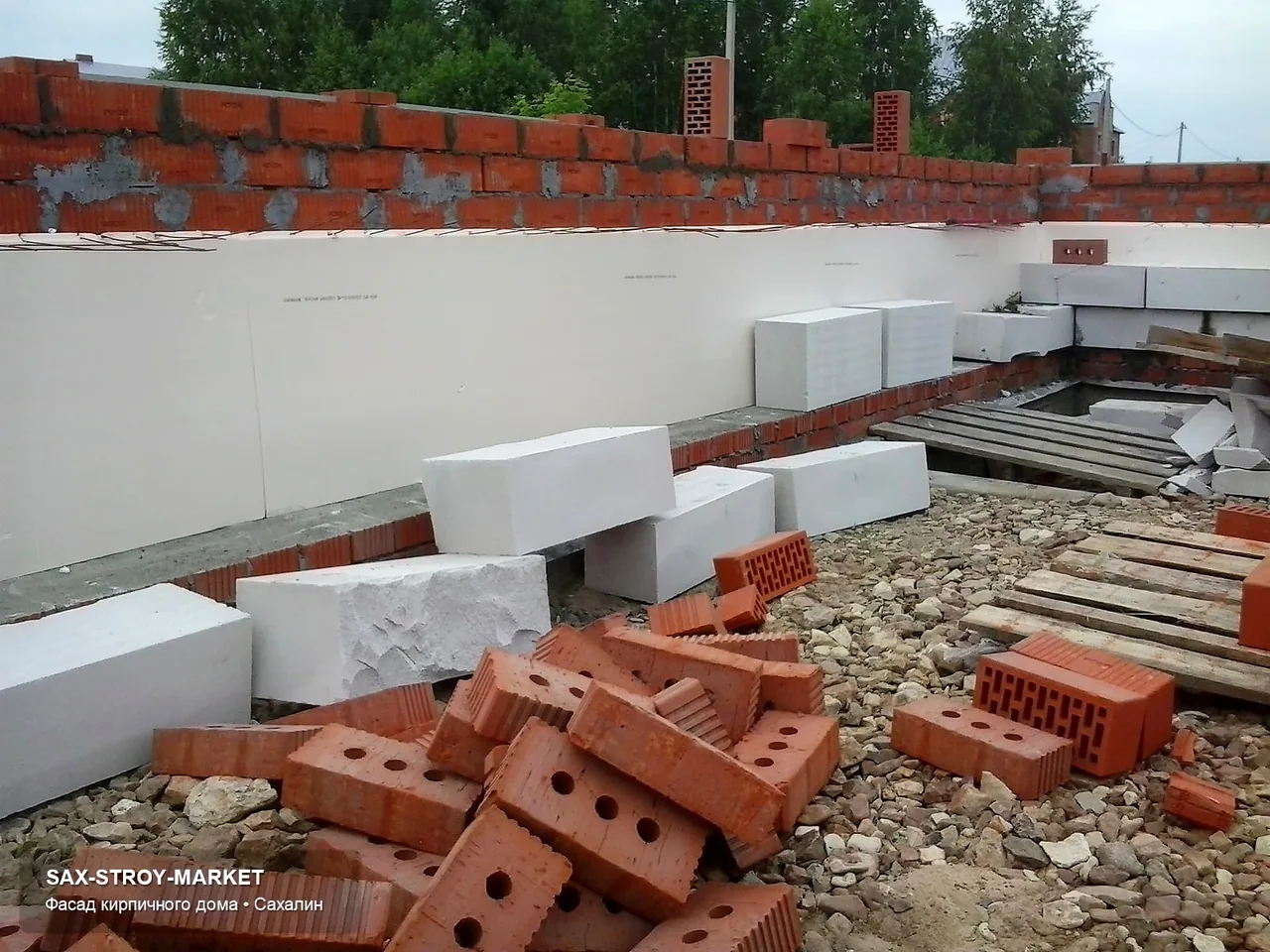 Готовый дом и участок: виден крыльцо, подъезд, двор, терраса и цокольная зона у места будущей отмостки. Такой ракурс нужен для подготовка к благоустройству в Южно-Сахалинске: какие переходы нужно учесть перед благоустройством.