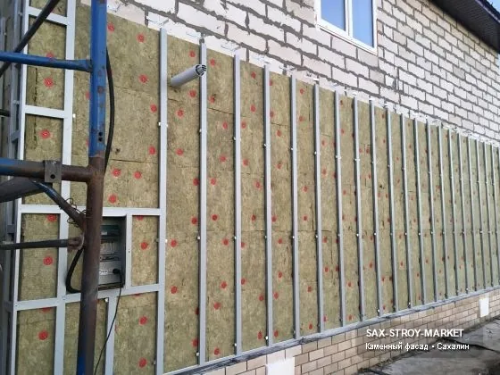 Фактурная отделка фасада. Читается стык панелей, угол и переход к откосу. При отделке цоколя согласуют высоту пояса и цвет камня; узел отмечают до закупки панелей, сайдинга или камня.
