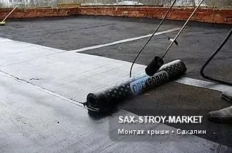 Участок крыши фиксирует этап: рулонная гидроизоляция, прогрев шва, нахлёст и рабочая полоса на плоскости. Рабочий участок, Сахалин: что проверить на месте — состояние основания, проверка парапета, влажный сезон.