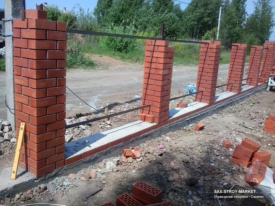 Металлический забор в Южно-Сахалинске: видно, как материал забора сочетается с воротами, столбами и фасадной линией. Сах-Строй Маркет помогает выбрать между металлическими секциями, евроштакетником, сеткой, кирпичом и комбинированным решением.